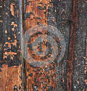 Textured wooden plane of red color with the surface of the tree blackened from time to time.