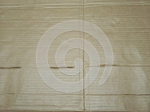 Textures : Corrugated cardboard with a light brown hue, showca : sing horizontal and vertical lines