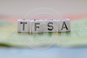 TFSA letters on white blocks with bills on a clear background