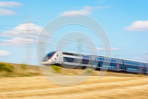 A TGV Duplex high-speed train in the french countryside with motion blur