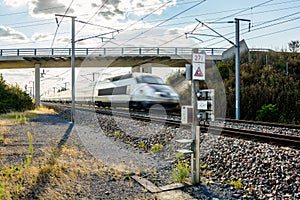 A TGV high speed train passing under a bridge in the french countryside with motion blur