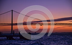 The 25th of April suspension bridge over the Tagus river, at sunset, in Lisbon, Portugal