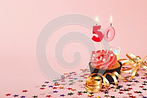 50th birthday cupcake with candle and sprinkles