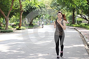 Thai adult beautiful girl doing running exercises in the park