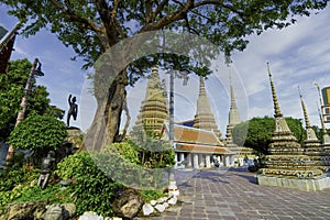 Thai ancient artistic architecture in Wat Poh with stupa complex and statue on sunny day and beautiful sky , Bangkok Thailand