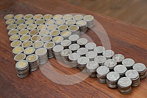 Thai Baht lots coin Arranged in arrow shape on with blurred background texture, Money stack for business planning investment