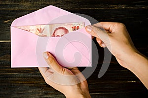 Thai banknote in an pink envelope