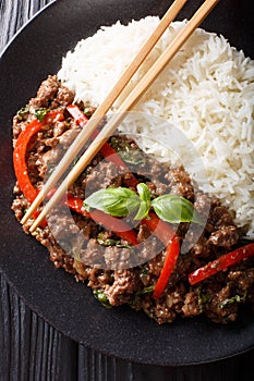 Thai Basil Beef, or Pad Gra Prow with rice side dish close-up. Vertical top view