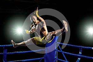 Thai boxer on boxing ring, jump and kicking