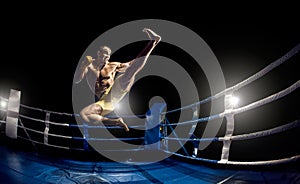 Thai boxer on boxing ring, jump and kicking