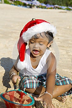 Thai boy with christmas hat on beach