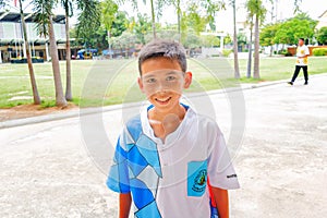 Thai boy smiling to the camera and feeling tired after playing football. Hua Hin, Thailand September 4, 2016