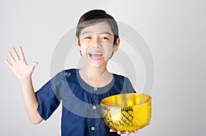 Thai boy splashing water by using hand from bowl