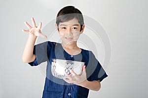 Thai boy splashing water by using hand from bowl