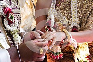 Thai bride and groom in Ceremony wearing a wedding ring of marriage celebration thai style at retro home in countryside of