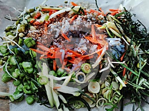 Thai chef cooking food fusion southern style Spicy Rice Salad with Vegetable on dish plate for served guest customer at restaurant