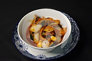 Thai chef cooking food side dish korean style cuisine salad vegetables kimchi or gimchi served on ceramic cup at restaurant cafe photo
