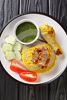 Thai Chicken Biryani kao mok gai served with Dipping Sauce and fresh vegetables closeup in the plate. Vertical top view