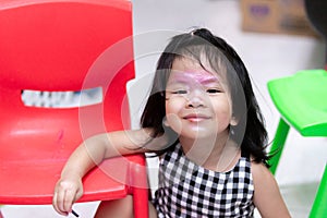 Thai child has cosmetics painted on her face. Children playing cosmetics, smiling proudly.