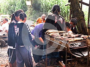Thai children karen ethnic group and tribe merchant cooking sweet potato roasted grilled on stove for sale thai people travelers