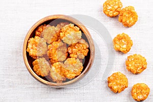 Thai chili rice crackers, spicy crispies, in wooden bowl on linen