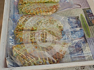 A Thai coconut waffle, so called ` Kanom Rung Peung ` or literally ` bee hive snack `, being put in a clear plastic bags photo
