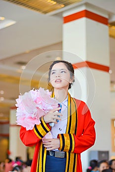 Thai college girl in academic gown is looking forward to the future in her graduation day