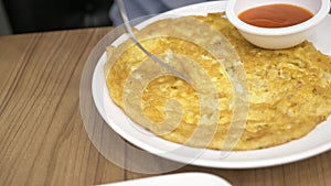 Thai cuisine - rice, omelet, vegetables with pork. a man eats Thai food in a restaurant. 4k, slow motion