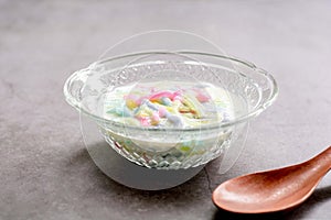 Thai dessert. Colorful of cendol with coconut milk in a clear bowl on a dark table. Delicious famous sweet dish in Thailand