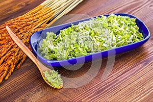 Thai dessert pounded unripe rice with shredded coconut on wood t