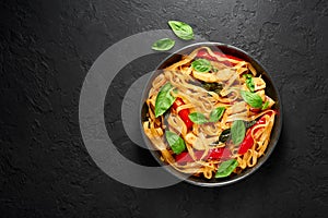 Thai Drunken Noodles or Pad Kee Mao in white plate at black slate background. Drunken Noodles is thai cuisine dish