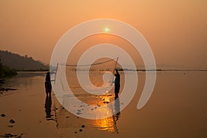 Thai fisherman silhouette in sunrise landscape Mekong river are