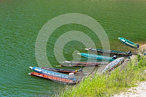 Thai fishing boats dock near the shore of Sirikitti dam reservoir.