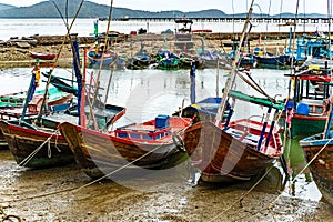 A Thai-flagged fishing boat is stranded on the pier.