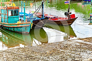 Thai-flagged fishing boats line the river in the bustling port.