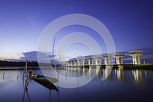 A Thai folk fishing boat made of wood, moored on the banks of the river in the morning