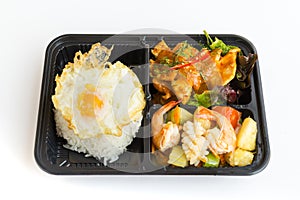 Thai food lunch boxes in plastic packages. Rice with red pork curry and .sweet and sour seafood