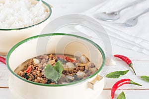 Thai food name Pad Ka Prao, Stir-fried pork with basil leaves beside have Cooked rice in classic food carrier