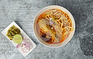 Thai food, Northern Style Curried Noodle Soup with Chicken on gray concrete table