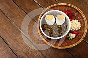 Thai food pound eggplant with boiled egg on wood table