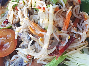 Thai food style, Papaya salad with tomato, shrimp, chili, bean, morning glory and cabbage as a background