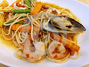 Thai food style Spaghetti Pad Kee Mao, Spaghetti with shrimp, mussels and vegetable in white bowl