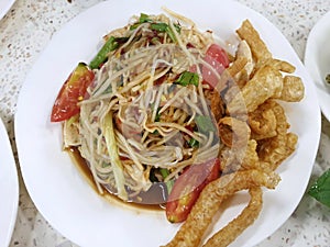 Thai food style, Top view of papaya salad and pork crackling in restaurant