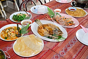 Thai food such as tom yum, grilled shrimp, fried fish and fresh vegetable chili paste. on the table