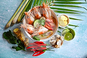Thai Food Tom Yum Kung, Hot and sour spicy shrimps prawns soup curry lemon lime galangal red chili straw mushroom on table food,