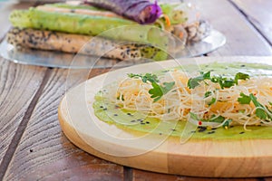 Thai food. Vermicelli rice wrap with coriander and spicy sauce on round wooden tray