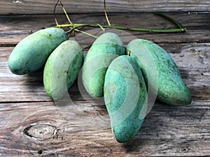 Thai fruit.Fresh green mangoes on the wooden table with natural light.