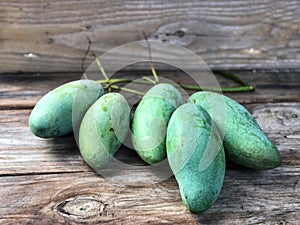 Thai fruit.Fresh green mangoes on the wooden table with natural light.