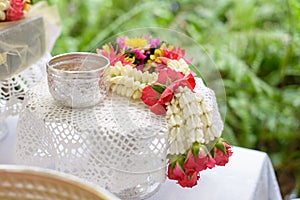 Thai garland Flowers and Water with jasmine and roses corolla in bowl on golden tray