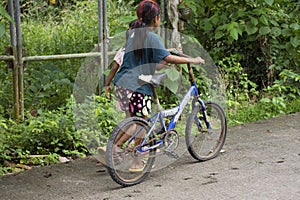 Thai girl and sisters people walking relax and biking bicycle on street at Baan Huay Nam Sai rural countryside village valley hill